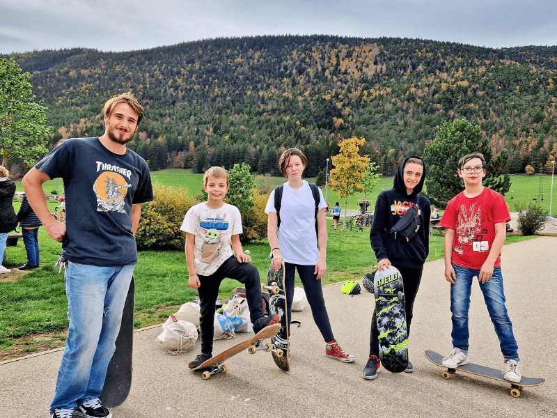Moniteur et groupe de jeunes skateurs qui profitent de la colo pour améliorer leur niveau