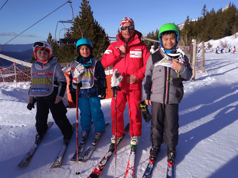 Groupe de jeunes qui apprennent le ski en colonie de vacances cet hiver