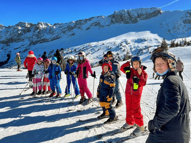 Groupe de jeunes qui apprend le ski avec des moniteurs ESF