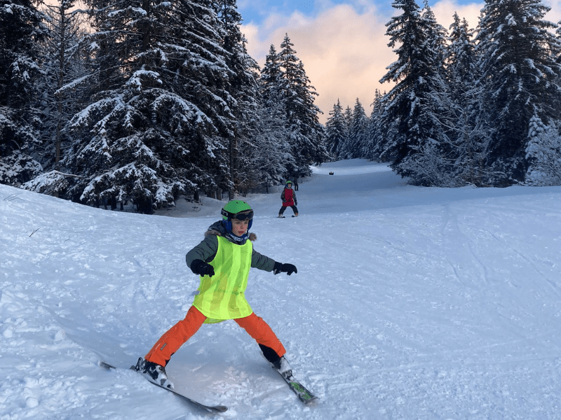 Enfant qui dévale la piste de ski en colonie de vacances Ski et Nature
