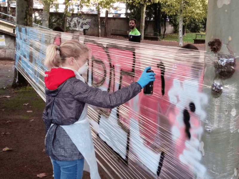 Jeune ado qui graff un mur durant sa colo de vacances au printemps