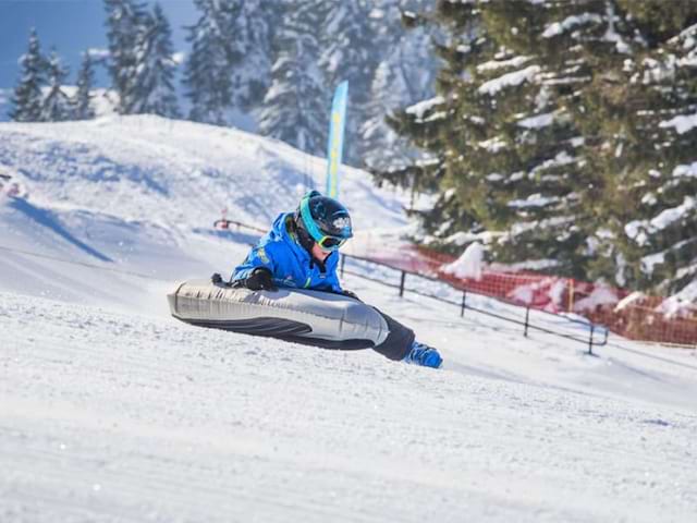 Jeune qui s'amuse à faire de l'airboard sur les pistes, durant sa colo de vacances