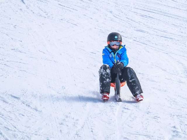 Jeune qui pratique le yooner sur la neige, durant sa colo de vacances d'hiver