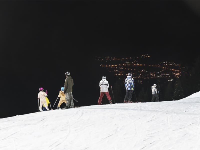 Groupe de skieurs en colo qui font du ski de nuit cet hiver
